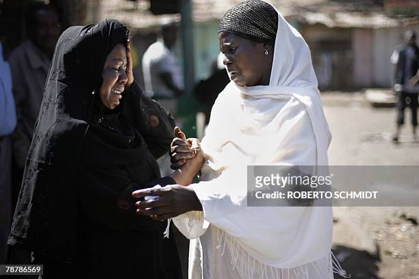 Rose Rehema , a resident and a store owner of the Kibera slum is comforted by a neighbor as they react to seeing the destruction of Rose's corner...