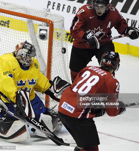 Sweden's goalie Jhonas Enroth fights for the puck with Canada's Brad Marchand and Claude Giroux during their final match at the 2008 IIHF World...