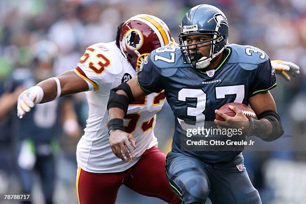 Running back Shaun Alexander of the Seattle Seahawks runs for 17-yards as linebacker Marcus Washinton of the Washington Redskins tries to tackle...