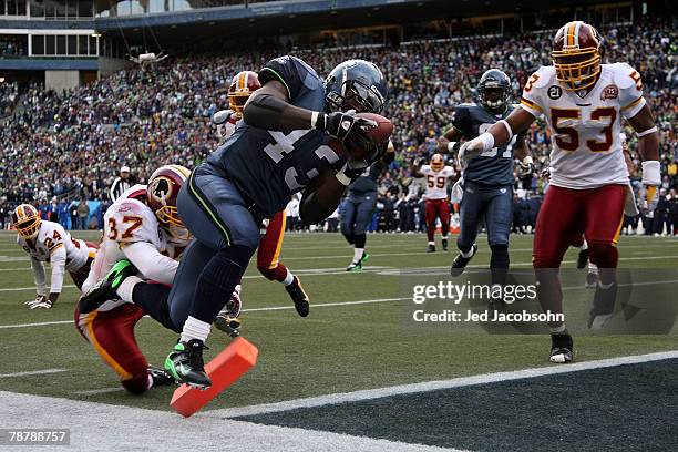 Fullback Leonard Weaver of the Seattle Seahawks runs the ball 17-yards for a touchdown in the first quarter against the Washington Redskins during...