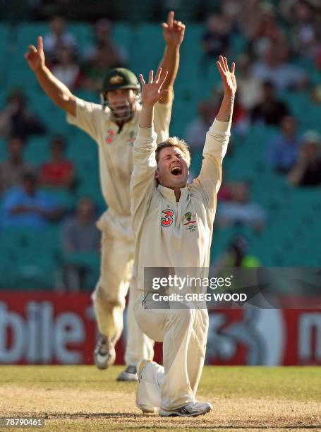 Australian bowler Michael Clarke with teammate Phil Jaques celebrate taking the wicket of R.P. Singh of India on the final day of the second Test...