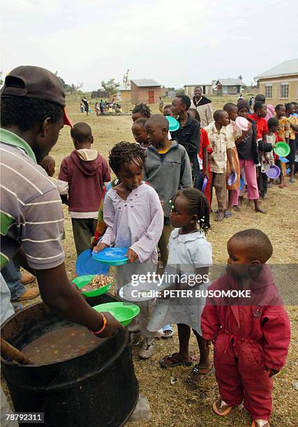 Kenyan refugee children from the Kikuyu tribe stand in line to receive food at Malaba's St. Jude Primary School on the Uganda-Kenya border, 05...