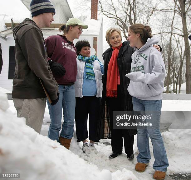 Democratic presidential candidate Sen. Hillary Clinton talks with people on the sidewalk as she canvases for votes through a neighborhood January 6,...