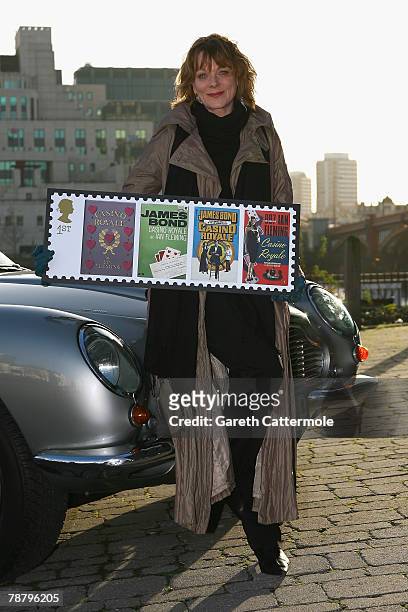 Actress Samantha Bond, who played Miss Moneypenny in the James Bond films, poses with an Aston Martin DB6 to launch a new set of stamps from The...