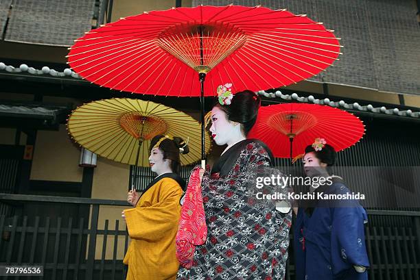 Traditional Japanese dancers Maiko and Geiko walk with an umbrella during a New Year's ceremony at the Gion Kobu Kaburenjo on January 7, 2008 in...