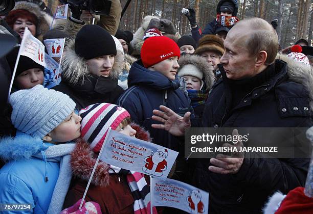 President Vladimir Putin greets children while celebrating Orthodox Christians in Veliky Ustyug, in the Vologda region, about 650 kilometers north of...