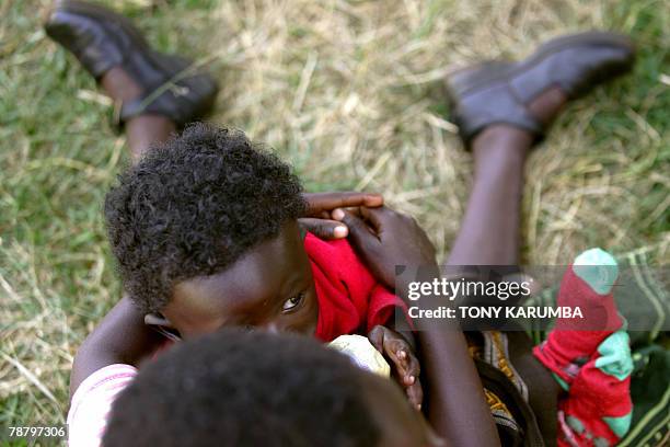 Child sits on a woman lap as IDP's fleeing the post elections violence, took refuge in a camp set up in a police station in Limuru, 40kms from...