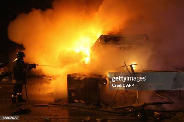 An Italian firefigther tries to extinguish a rubbish container next to an autobus in fire which was lite up by demonstrators against the Pianura...