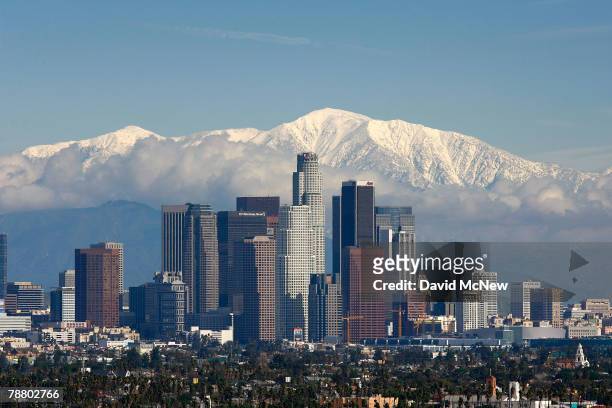Fresh snow blankets the mountains behind the downtown skyline after a series of storms that hammered northern California delivered much needed...