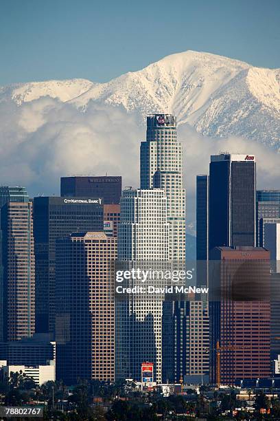 Fresh snow blankets the mountains behind the downtown skyline after a series of storms that hammered northern California delivered much needed...