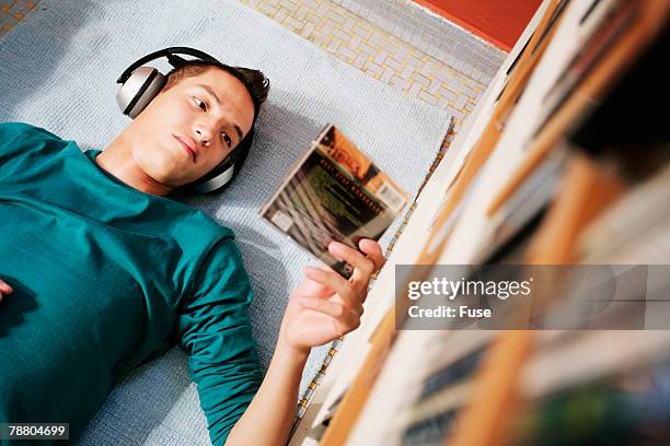 young man reading cd case - cd case stock pictures, royalty-free photos & images