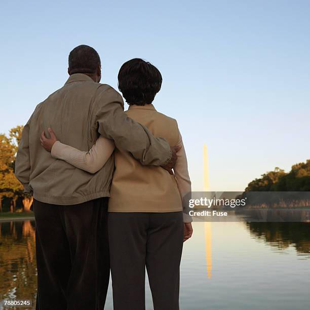 middle aged couple looking at washington monument - reflecting pool stock pictures, royalty-free photos & images