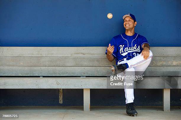 baseball player sitting in the dugout - dugout baseball stock pictures, royalty-free photos & images