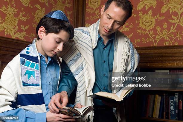 father assisting son with torah - jewish people stock-fotos und bilder