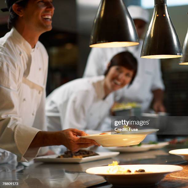 chef holding plate - chef team stock pictures, royalty-free photos & images