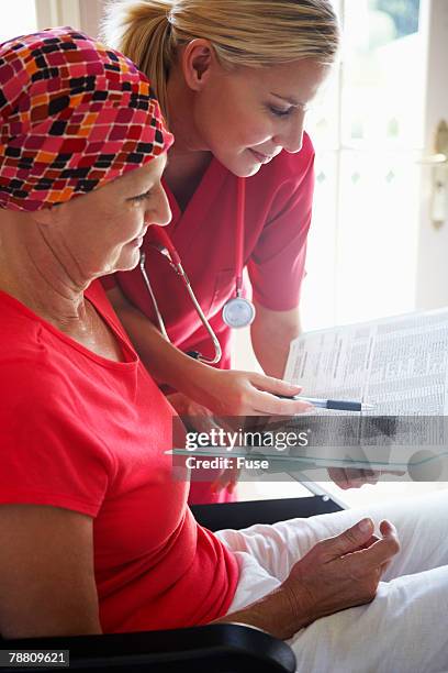 nurse reviewing paperwork with patient - naughty nurse images stock-fotos und bilder