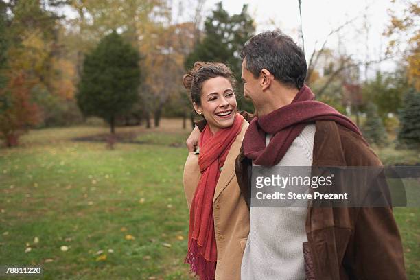 affectionate couple walking in park - steve prezant stock pictures, royalty-free photos & images