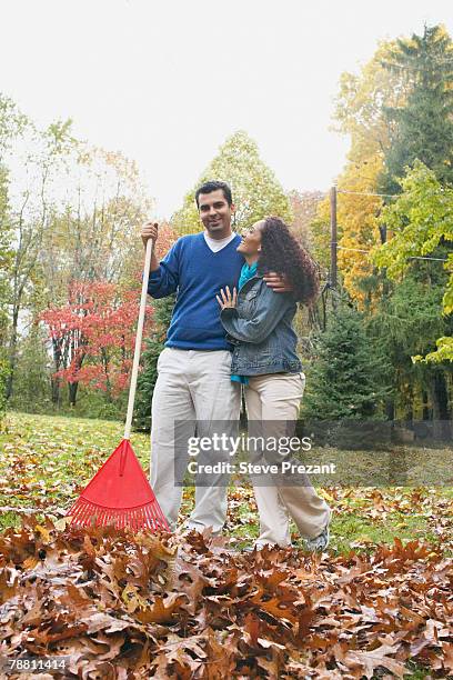 couple raking leaves - steve prezant stock pictures, royalty-free photos & images