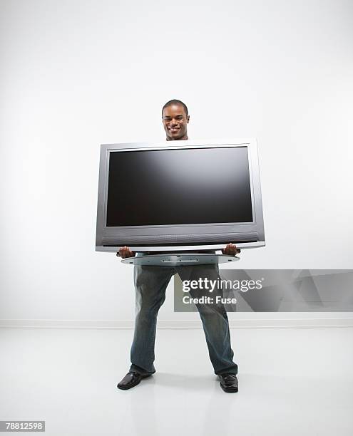 man holding television set - carrying tv stock pictures, royalty-free photos & images