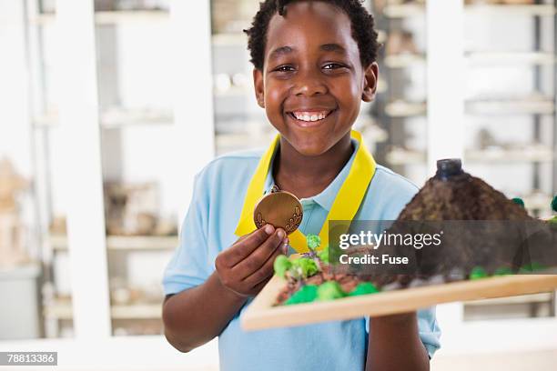 boy holding science fair project - science fair volcano stock pictures, royalty-free photos & images