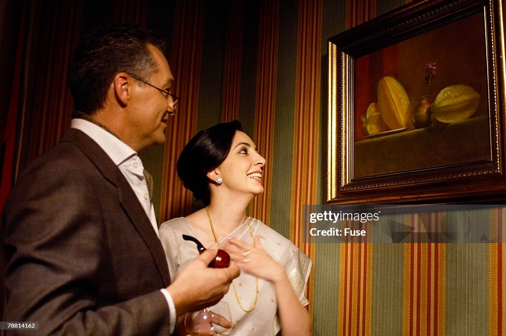 Couple Admiring Oil Painting on Wall