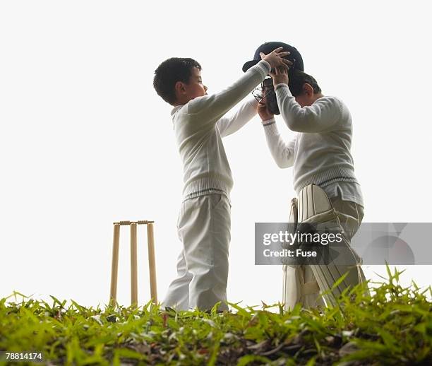 two boys playing cricket - cricket uniform stock pictures, royalty-free photos & images