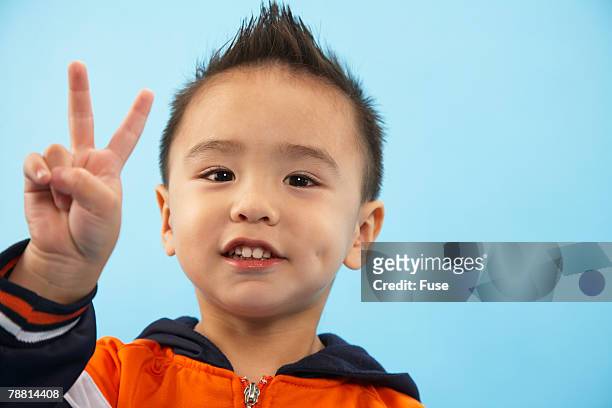 portrait of boy giving peace sign - two fingers stock pictures, royalty-free photos & images