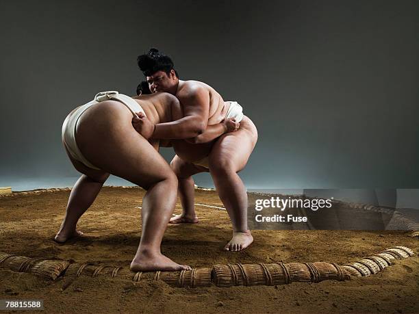 sumo wrestlers facing off in ring - sumo wrestling stock pictures, royalty-free photos & images