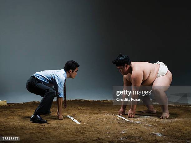 businessman wrestling sumo wrestler - mismatch fotografías e imágenes de stock