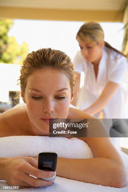 woman getting therapeutic massage on cell phone - mobile massage table stock pictures, royalty-free photos & images