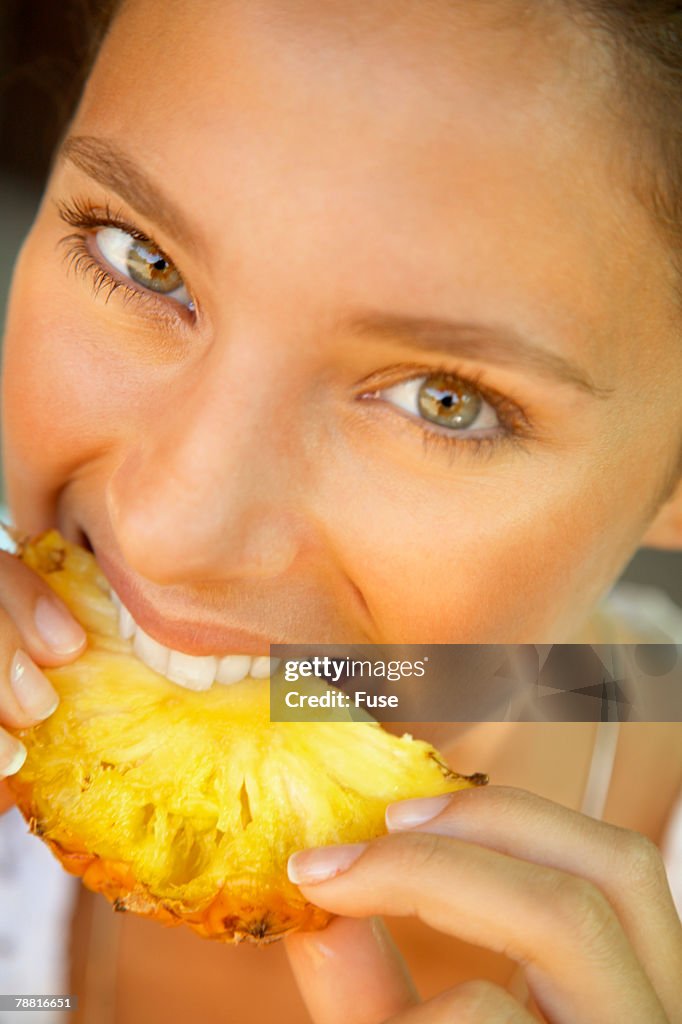 Woman Eating Slice of Pineapple