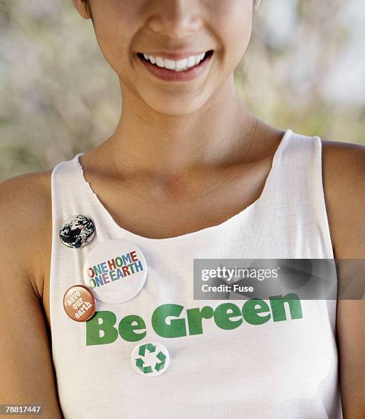 young woman wearing environmentalist tank top and buttons - campaign button stock pictures, royalty-free photos & images