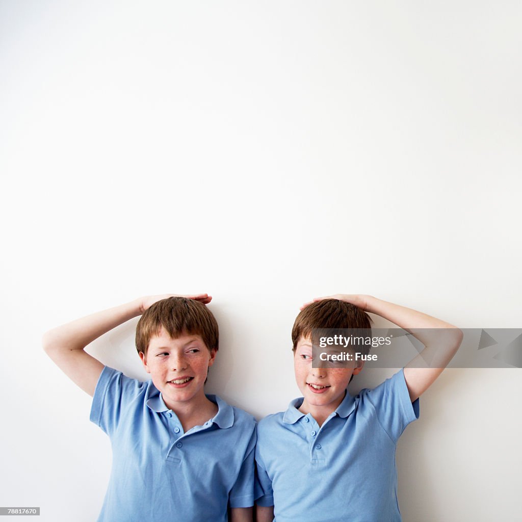 Identical Twin Pre-teen Boys Measuring Height