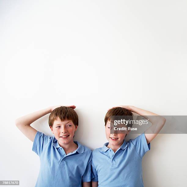 identical twin pre-teen boys measuring height - headshot of a teen boy stockfoto's en -beelden