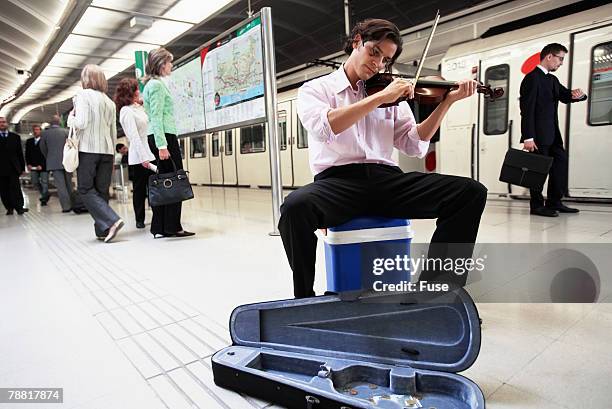 man busking for change in subway station - busker stockfoto's en -beelden