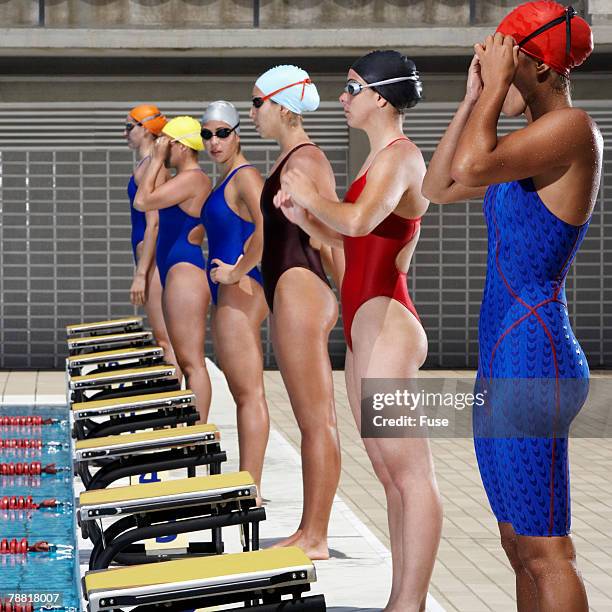 swimmers preparing to dive in pool - swimming competition stock pictures, royalty-free photos & images