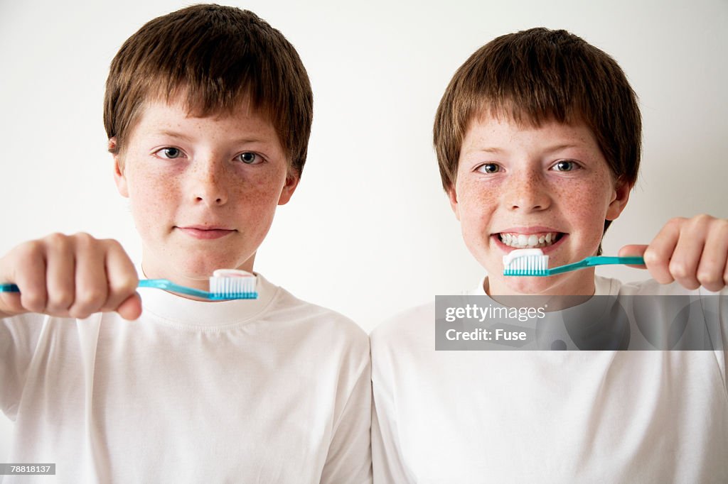 Identical Twin Pre-teen Boys Brushing Teeth