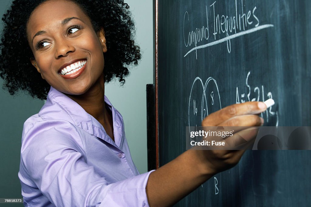 Teacher Writing Equation at Blackboard