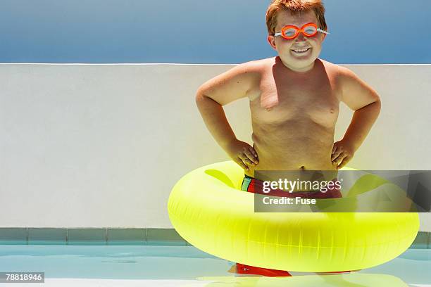 boy wearing inner tube - swimming tube stockfoto's en -beelden
