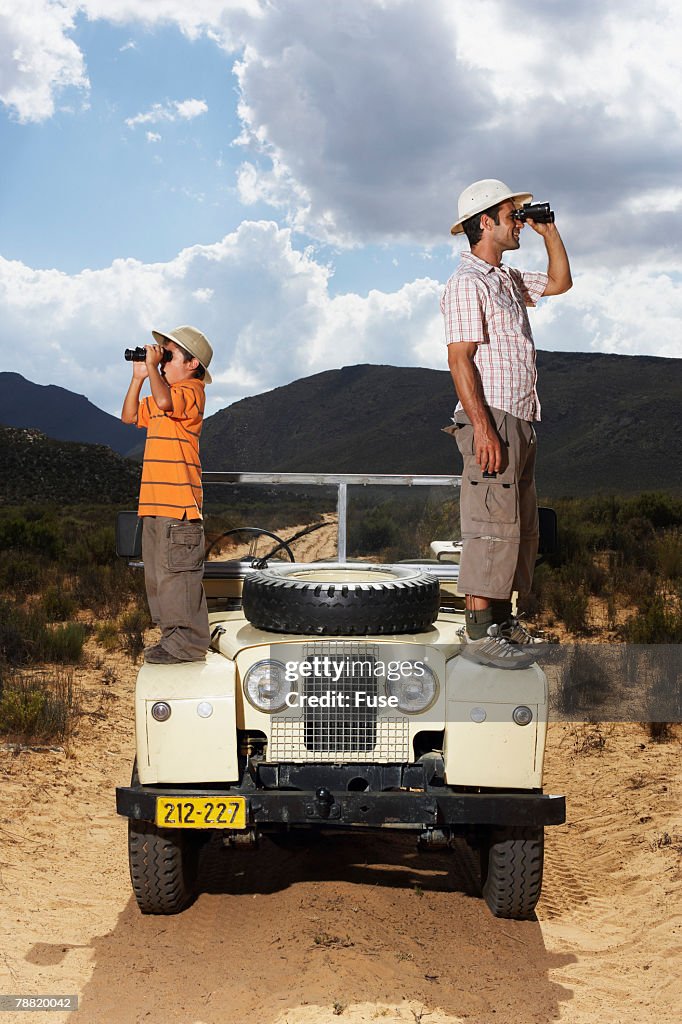 Father and Son on Safari Looking Through Binoculars