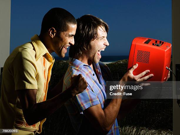 two excited men watching sport on television - shes my best friend stockfoto's en -beelden