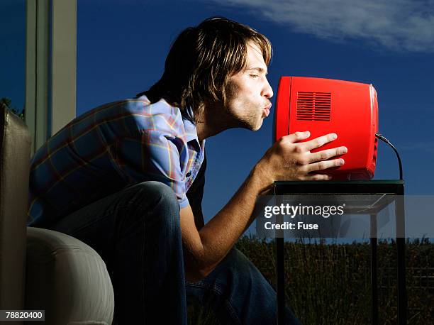 excited sports fan kissing television - tragbarer fernseher stock-fotos und bilder