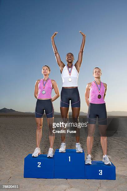 athletes on winner's podium - winners podium people stock pictures, royalty-free photos & images