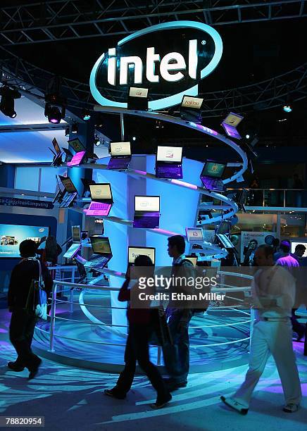 Attendees walk past a display of computers at the Intel Corp. Booth at the 2008 International Consumer Electronics Show at the Las Vegas Convention...