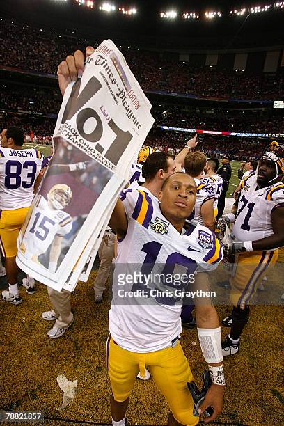 Jonathan Zenon of the Louisiana State University Tigers raises the trophy after defeating the Ohio State Buckeyes 38-24 in the AllState BCS National...