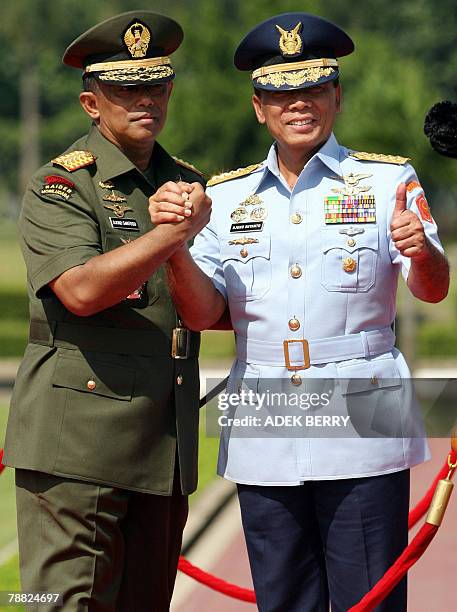 Outgoing Indonesian armed forces chief General Djoko Suyanto shakes hands with incoming armed forces chief General Djoko Santoso during a ceremony in...