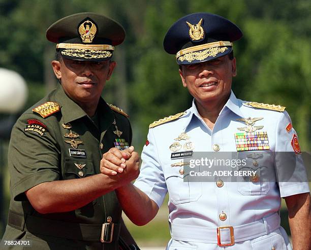 Outgoing Indonesian armed forces chief General Djoko Suyanto shakes hands with incoming armed forces chief General Djoko Santoso during a ceremony in...