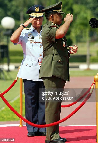 Outgoing Indonesian armed forces chief General Djoko Suyanto and incoming armed forces chief General Djoko Santoso salute during a ceremony in...