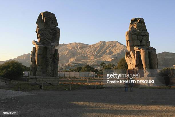 Couple of tourists visit the Colossi of Memnon in Luxor 23 December 2007. AFP PHOTO/KHALED DESOUKI