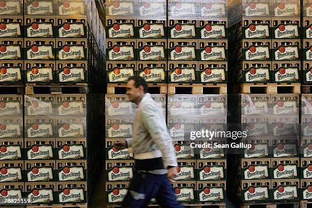 Worker walks past cases of freshly-brewed Pilsner-Urquell lager beer at the Prazdroj brewery November 15, 2006 in Pilsen, Czech Republic. Prazdroj,...